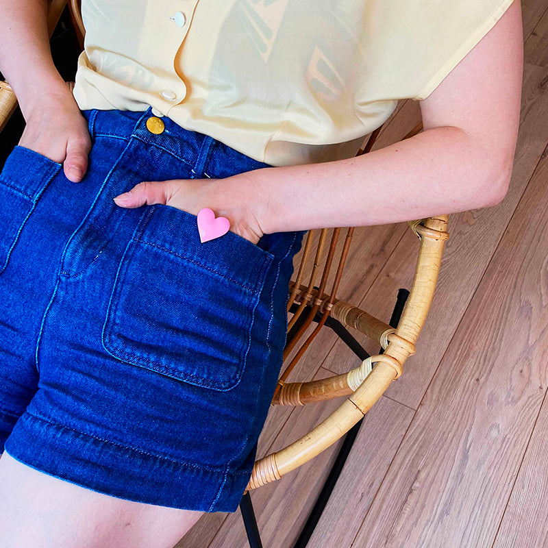 Bijou clip en forme de cœur rose porté sur short en jean
