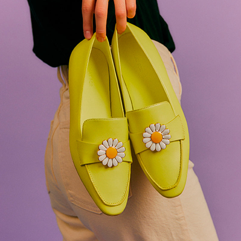 Bijou clip en forme de marguerite porté sur mocassin citron