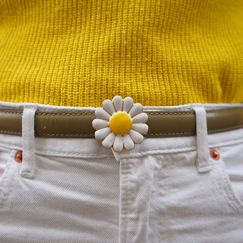 Bijou clip en forme de marguerite porté sur ceinture