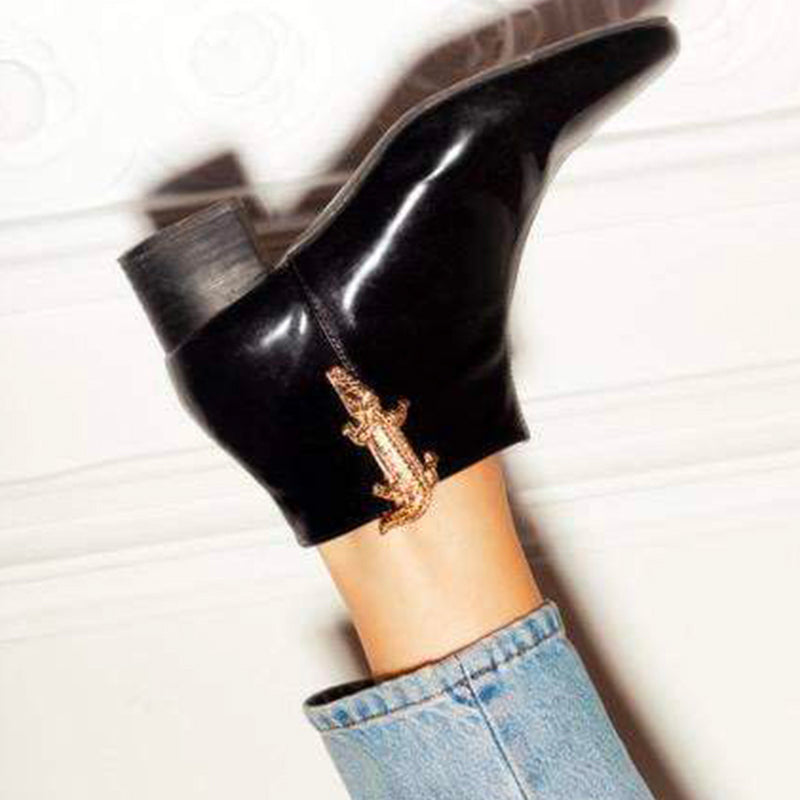 Bijou clip en forme de crocodile doré porté sur bottine noire