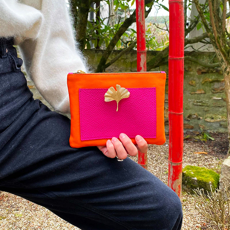 Bijou clip en forme de feuille de gingko dorée sur pochette rose et orange