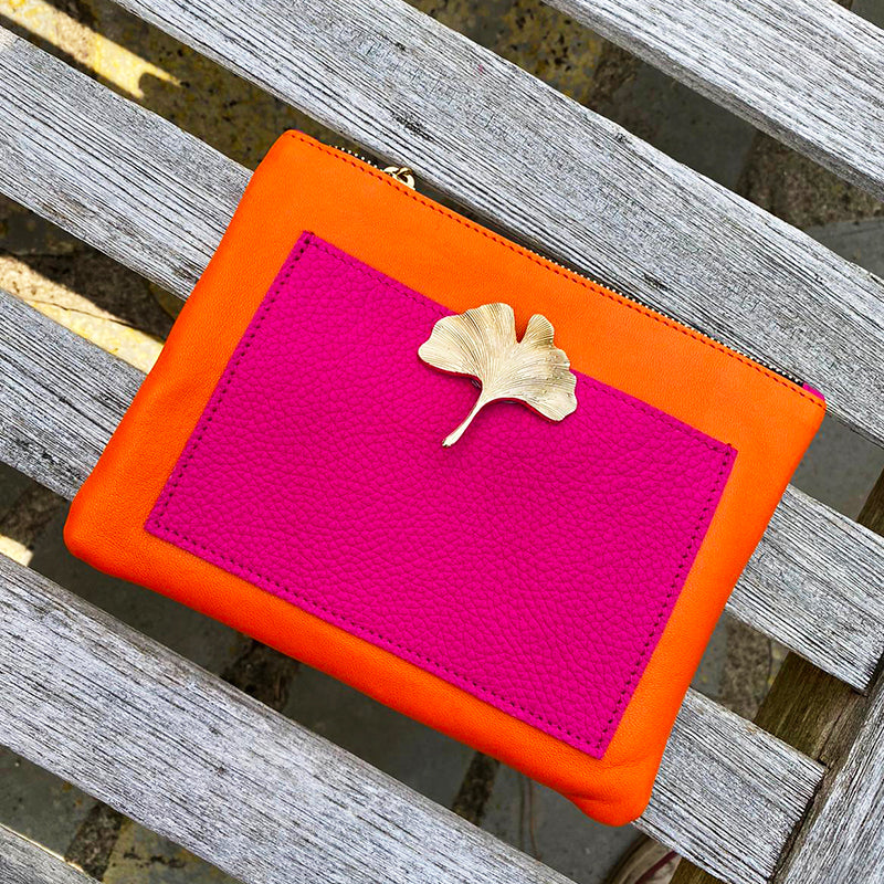 Bijou clip en forme de feuille de gingko dorée sur pochette rose et orange