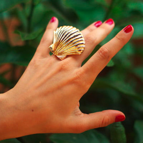 Bijou clip coquillage doré porté sur bague