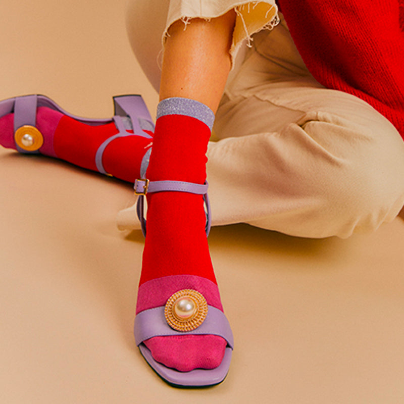 Bijou clip rond doré avec perle sur sandales à talons parme et chaussettes rose et rouge