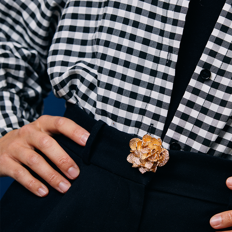 Bijou clip rose des sables de couleur doré sur un pantalon noir. collection octobre rose de clap paris